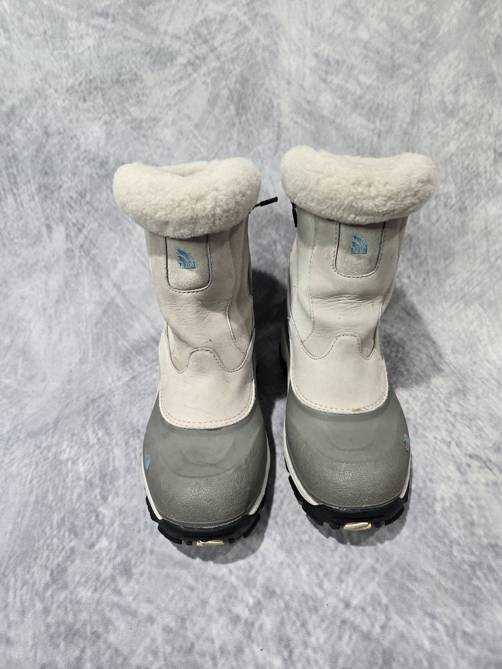 The North Face women's winter boots featuring a distinctive light gray leather